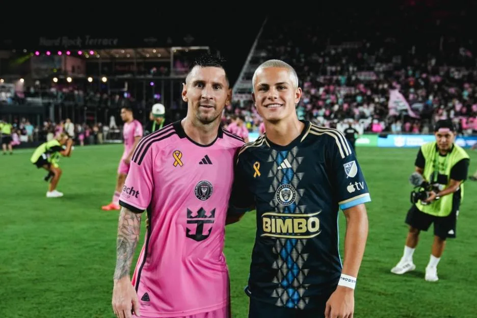 Inter Miami forward Lionel Messi and Philadelphia Union midfielder Cavan Sullivan pose together on the field.