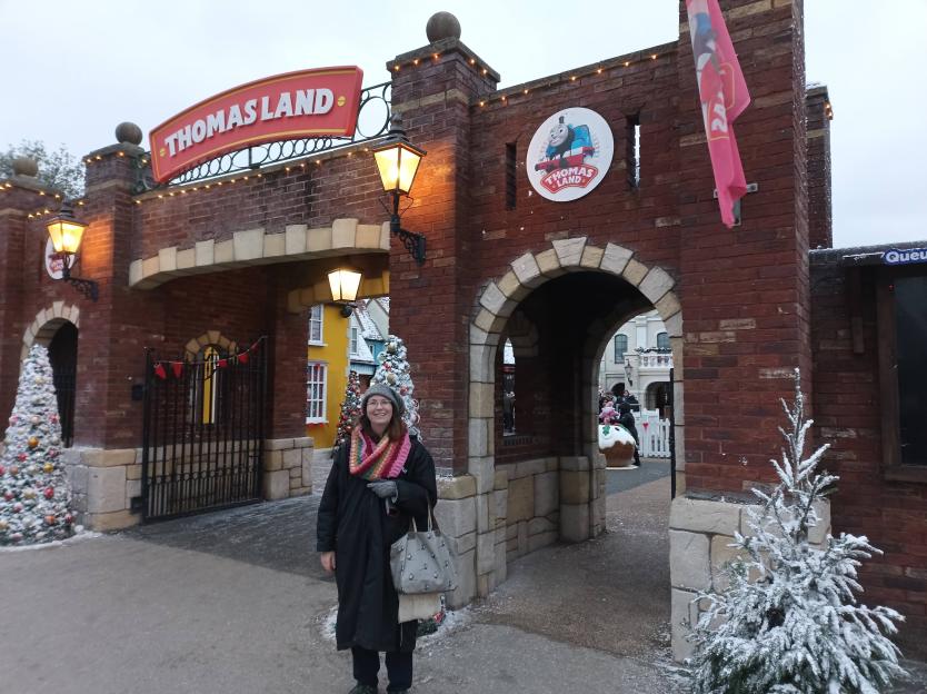 A woman stands in front of the entrance to Thomas Land at Drayton Manor, which is decorated for Christmas.