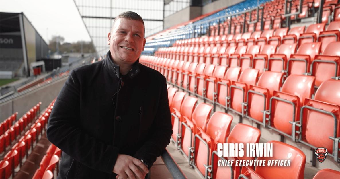Chris Irwin, Chief Executive Officer, standing in a stadium.