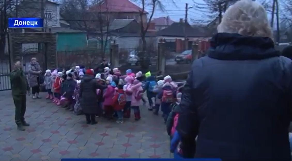 Adults lining up children for transport.