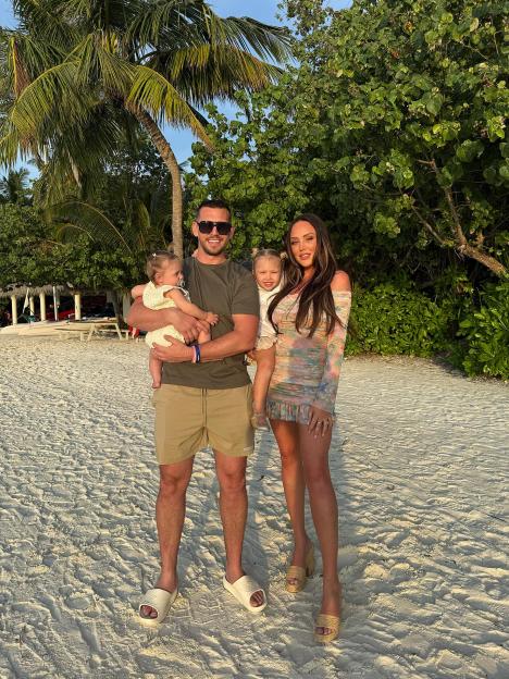 Charlotte Letitia Crosby, a man, and two toddlers on a sandy beach.