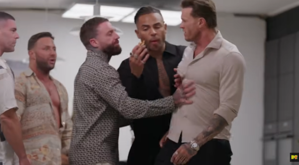 Three men restraining two other men from fighting.