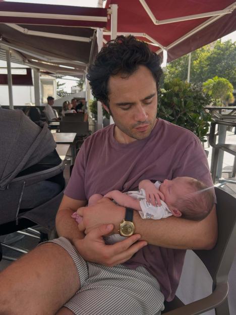 Toby Sebastian holding his newborn child.