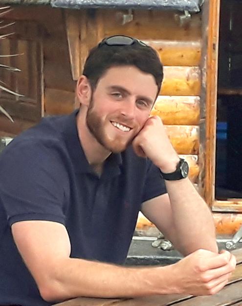 Andrew Harper in a blue polo shirt, smiling at the camera.