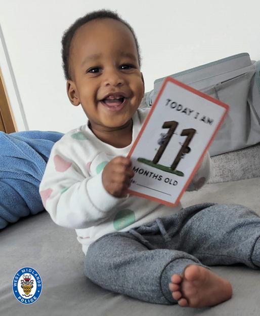 Noah Sibanda, a smiling baby, holds a card that reads "Today I am 11 months old."