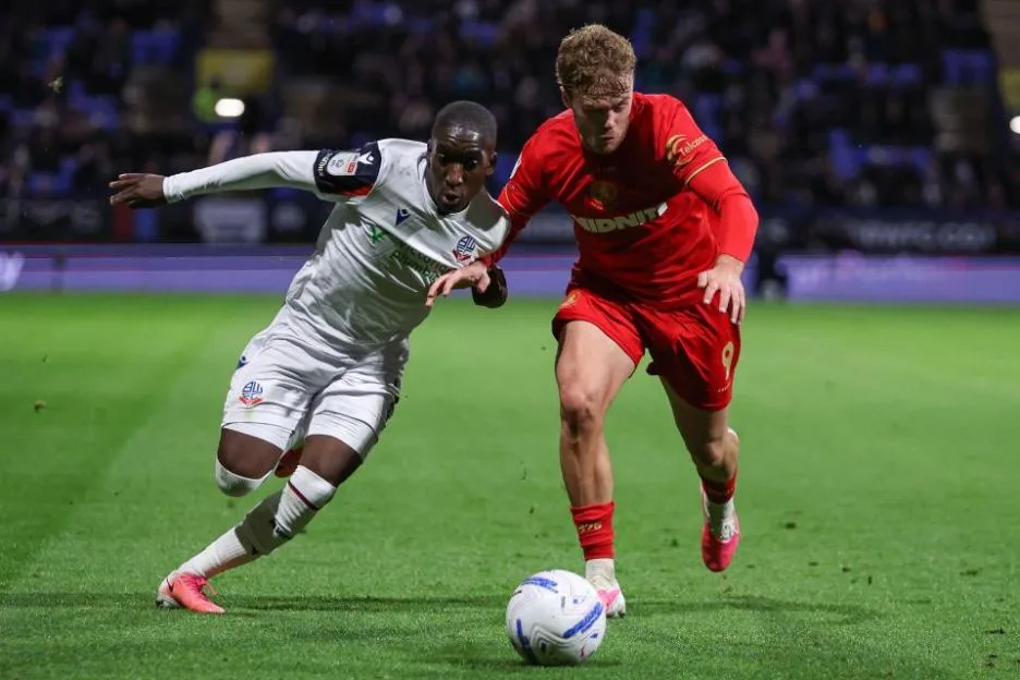 Two football players battle for possession of the ball during a match between Bolton Wanderers and Middlesbrough.