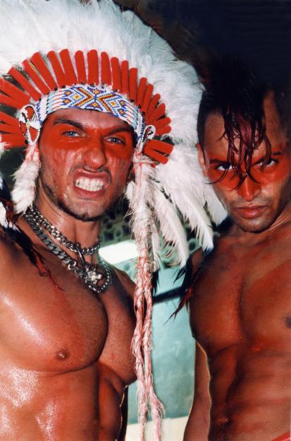 Two shirtless men with red body paint and costumes at the Manumission party in Ibiza.
