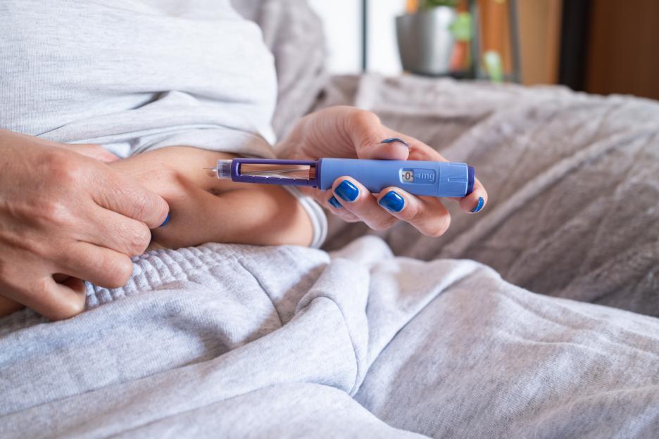 unrecognizable mature overweight diabetic woman injecting a syringe of semaglutide into her belly.medication for the medical treatment of obesity.