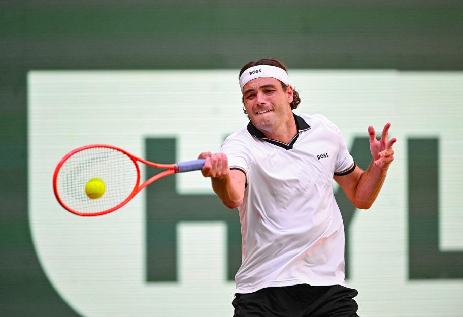 Taylor Fritz returning a tennis ball with a forehand stroke.