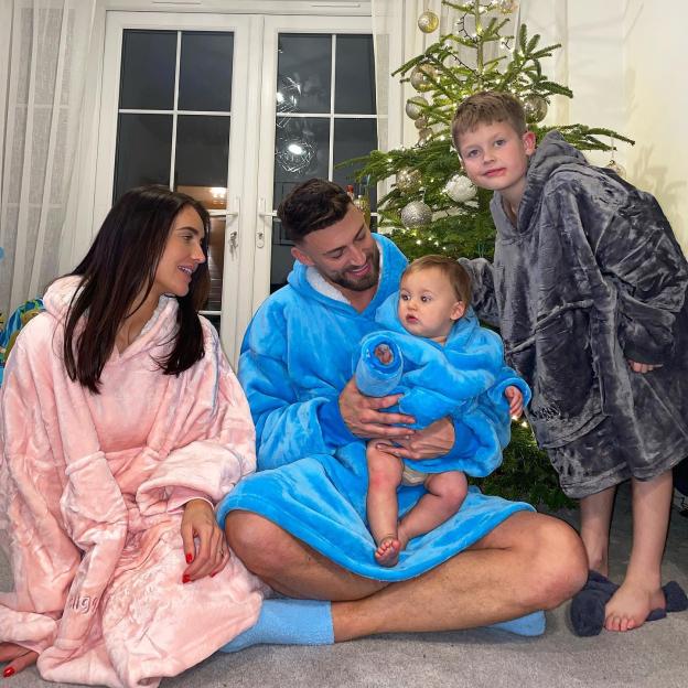 Jake Quickenden with girlfriend Sophie Church, son Leo, and stepson Freddie in matching loungewear by a Christmas tree.