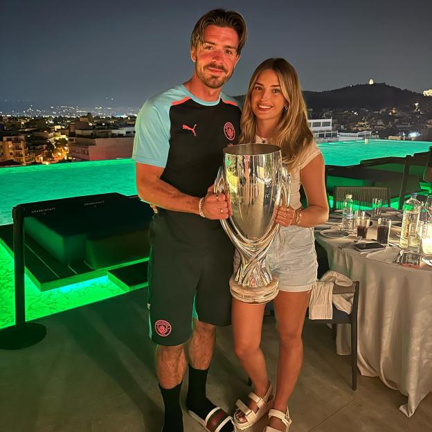 Jack Grealish and Sasha Attwood holding the UEFA Super Cup trophy.