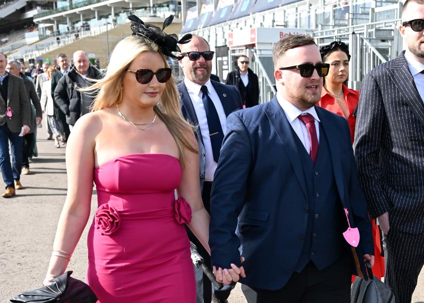Racegoers Luke Littler and Faith Millar holding hands at the Cheltenham Festival.