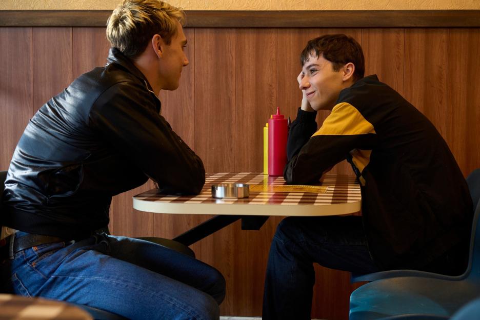 Max (Calam Lynch) and Byron (Ellis Howard) face each other across a checkered table.