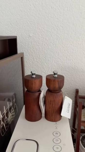 Two dark wood salt and pepper grinders with silver tops.
