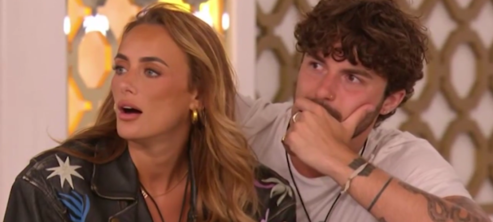 A woman with long blonde hair and a man with curly brown hair look shocked.