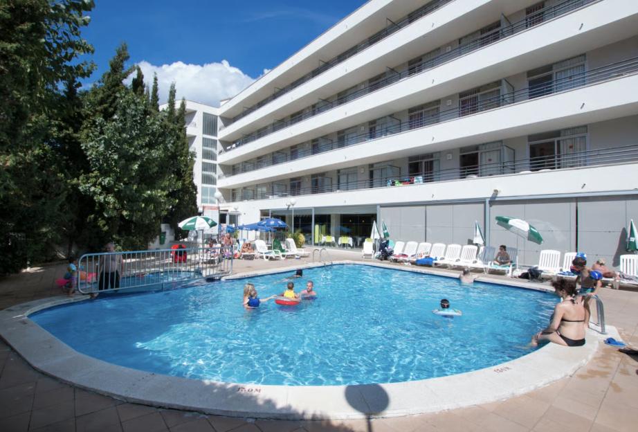 MedPlaya Esmeraldas Aparthotel with a pool full of people swimming and sunbathing.