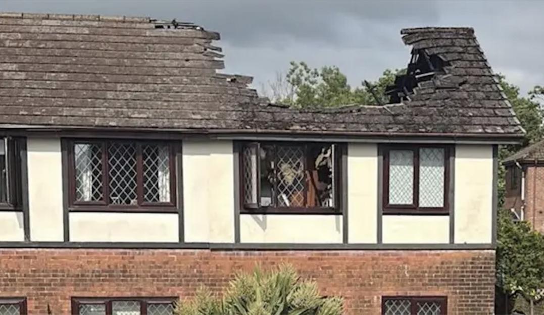 The roof of a semi-detached house with significant fire damage.