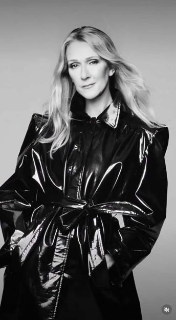Celine Dion in a black patent trench coat.