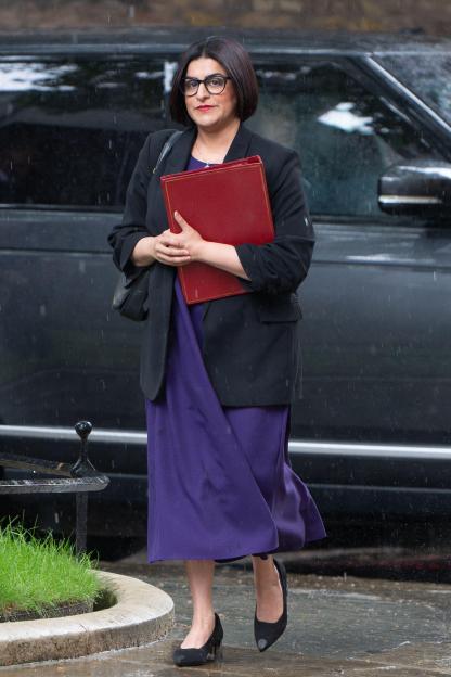 Shabana Mahmood, UK Home Secretary, carrying a red folder.