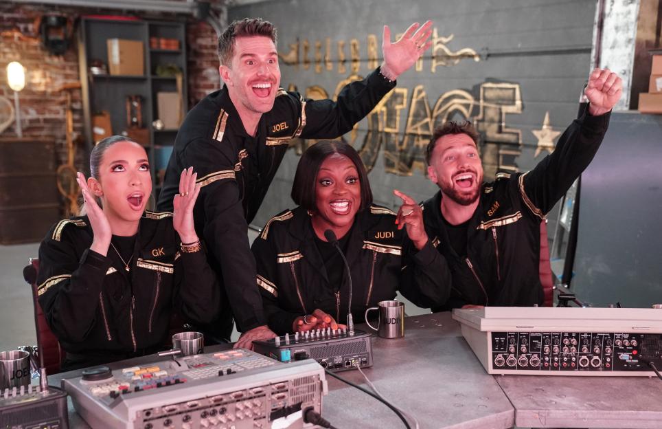 GK Barry, Joel Dommett, Judi Love and Sam Thompson reacting animatedly while seated at a control panel.