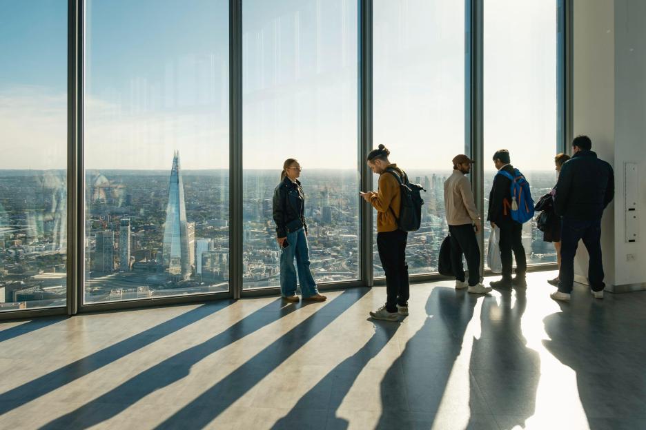 Visitors at Horizon 22, London's highest free public viewing gallery, looking out at the city skyline including the Shard.