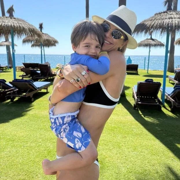 Vogue Williams holding her son Otto outdoors by the sea.
