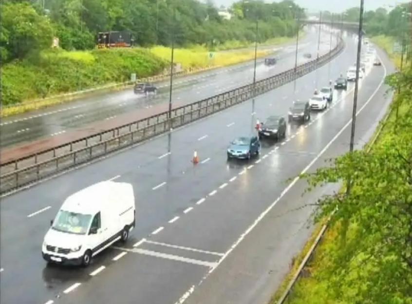 Traffic camera shows cars on a wet highway with some traffic congestion on the right-hand lanes.