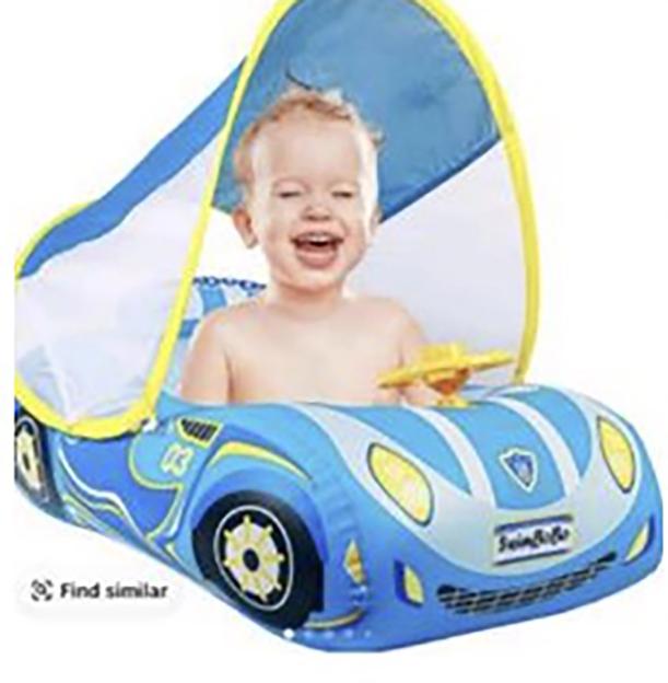 Happy baby in a blue inflatable car float with a sunshade.