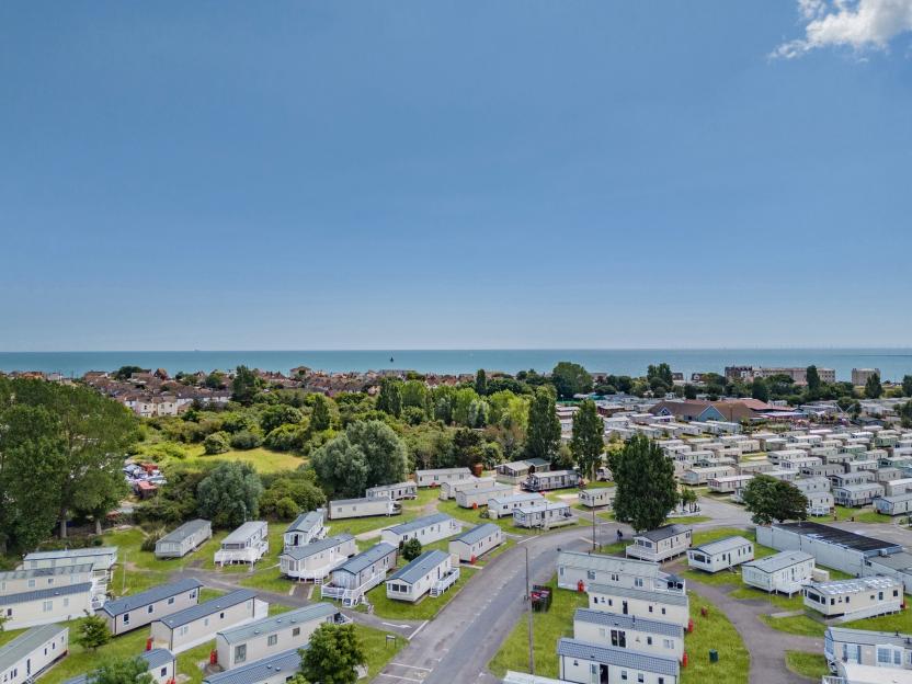 Aerial view of a caravan park near the sea with numerous mobile homes.