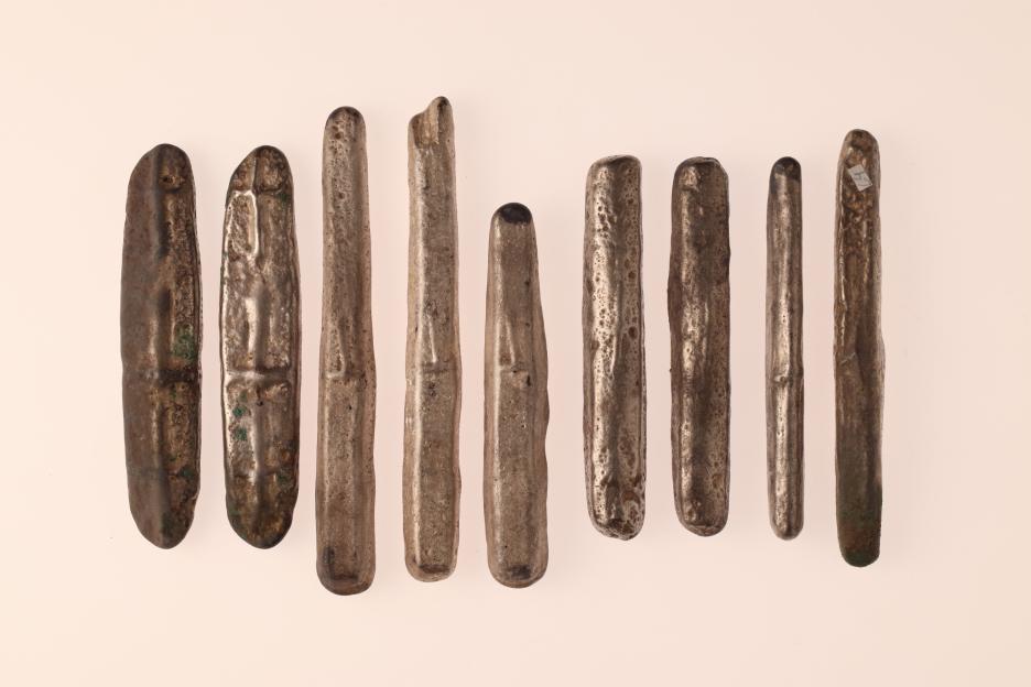 Nine elongated silver bars from a Viking Age hoard.