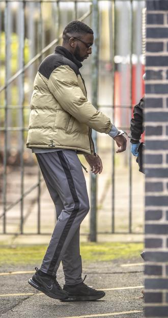 Gift Oladele arriving in handcuffs at Mold courts for his rape trial.