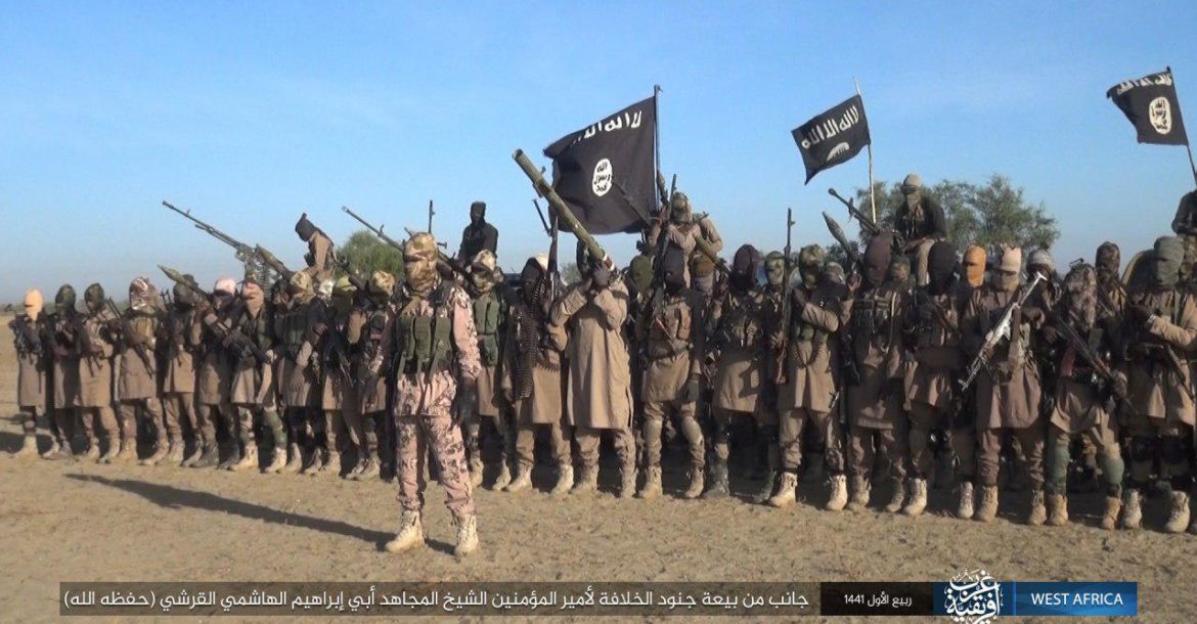 Militants in military fatigues and face coverings stand in formation, holding various weapons, with ISIS flags visible.