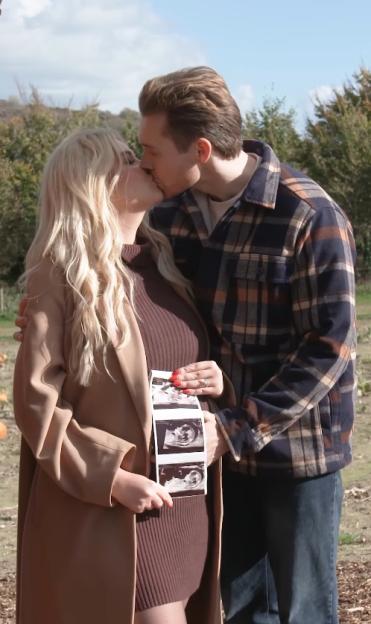 Amy Hart and her partner kissing, while she holds up ultrasound scans.