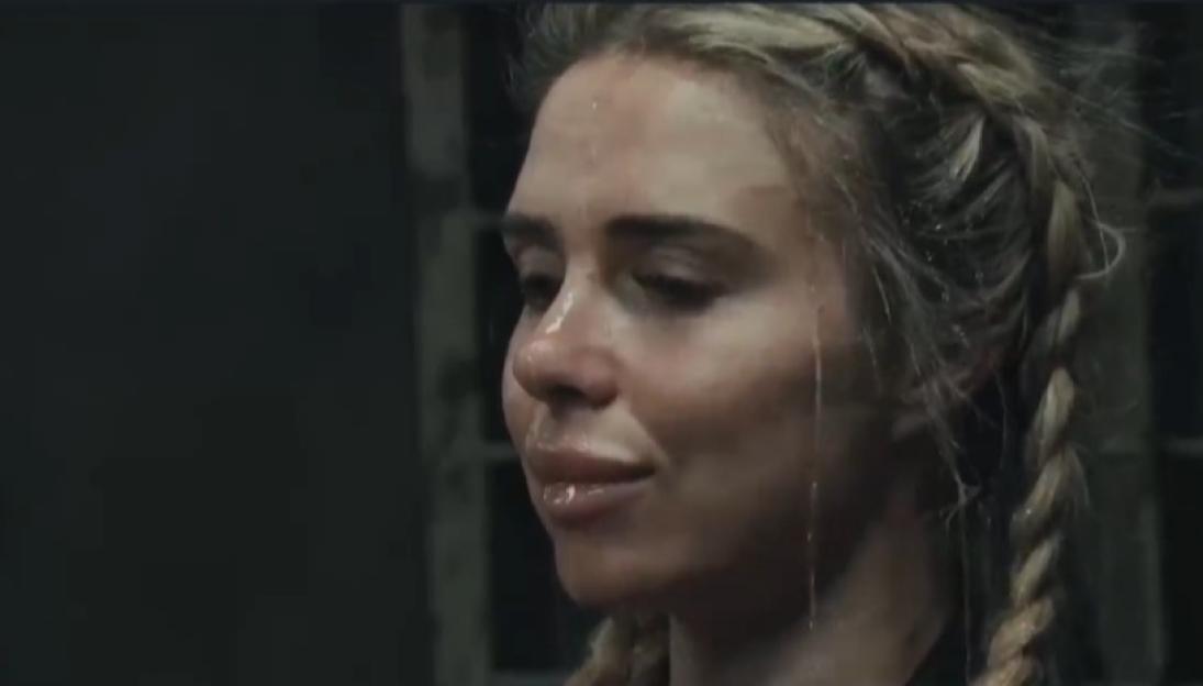 A woman with braided hair and a wet face looks off to the side.