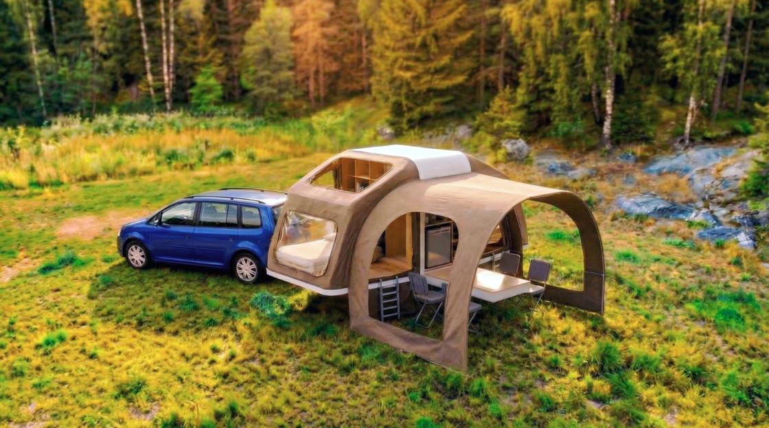 An expandable home tent unfolded from the back of a blue car in a grassy field.