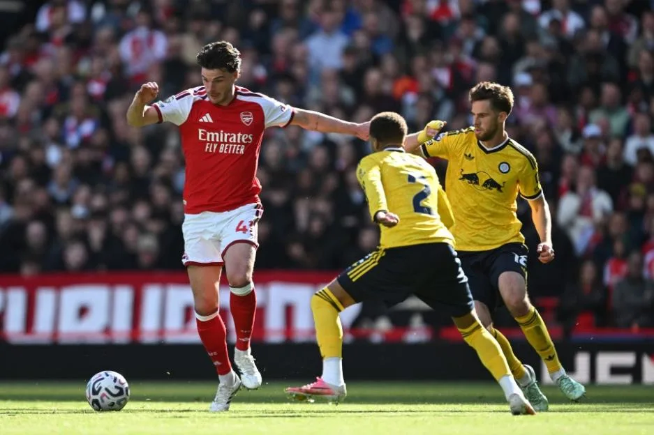 Declan Rice of Arsenal is put under pressure from Anton Stach and Jayden Bogle of Leeds United.