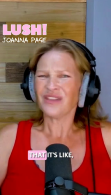 Joanna Page wearing headphones with a microphone in front of her, making a face as if disgusted.