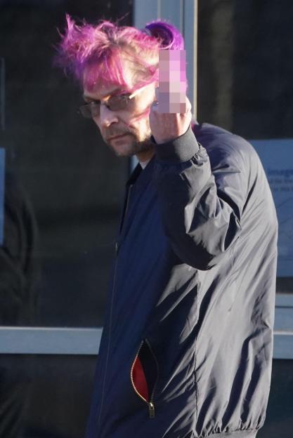 Person with purple hair giving the middle finger.