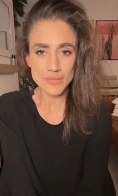 Katie Waissel in a black top with her brown hair down, looking at the camera.