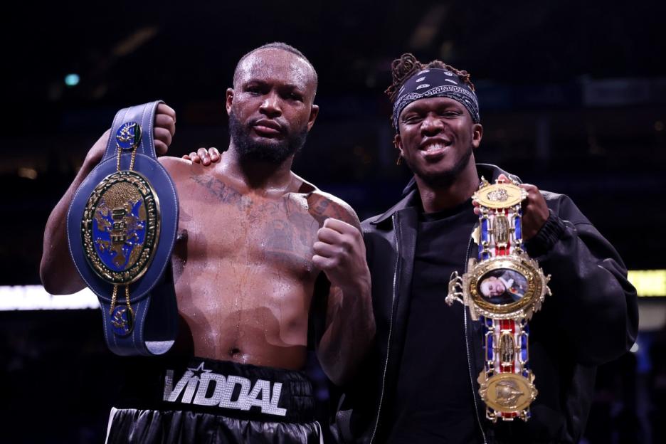 Dereck Chisora and KSI posing with championship belts.