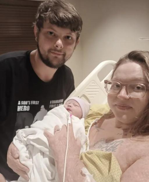 A couple holding their newborn baby in a hospital room.