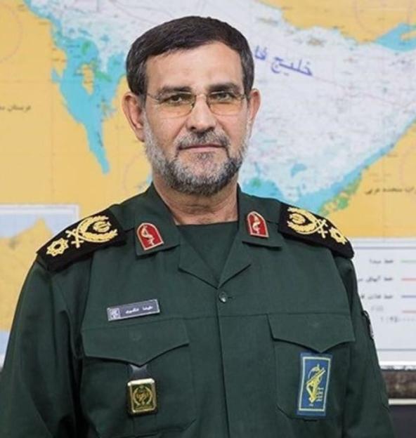 A bearded man in a military uniform with epaulets, against a blurred map background.