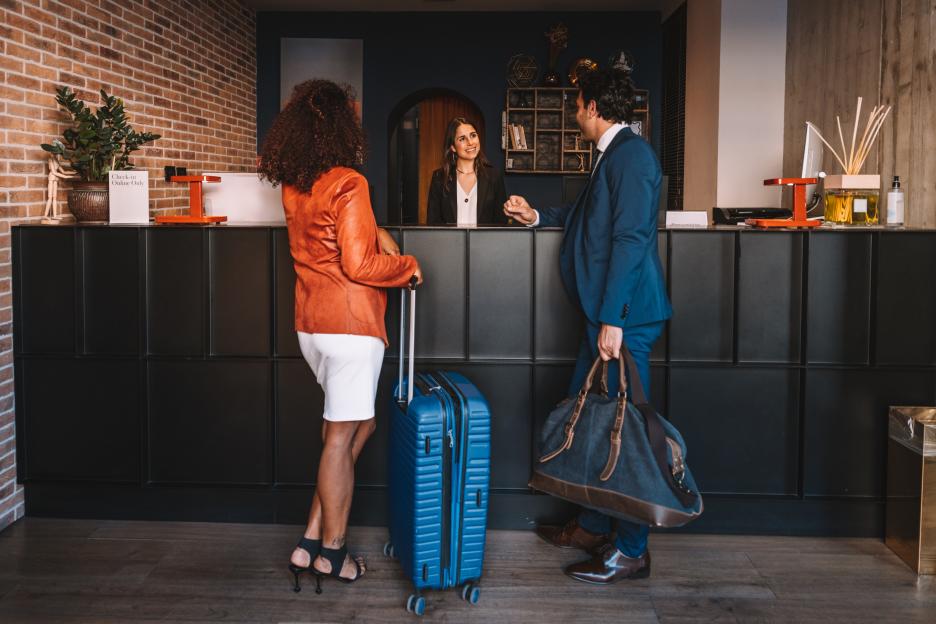 Business people checking-in at hotel reception desk