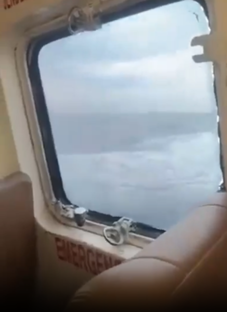 View from a plane window showing the ocean below.