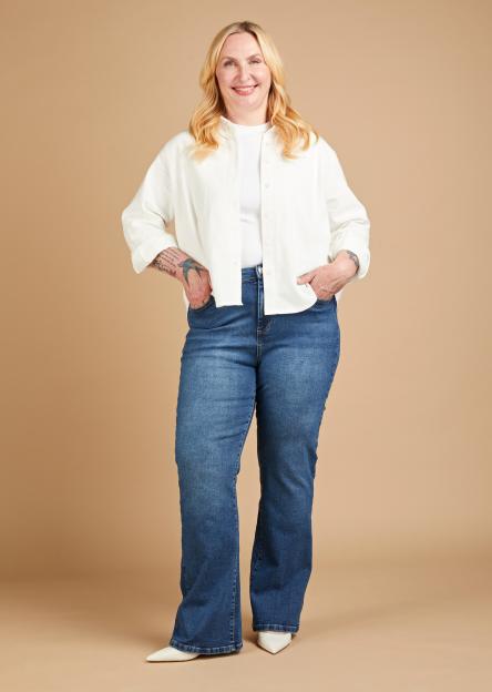 Anniki Sommerville wearing flared jeans, a white t-shirt, and a white button-down shirt.