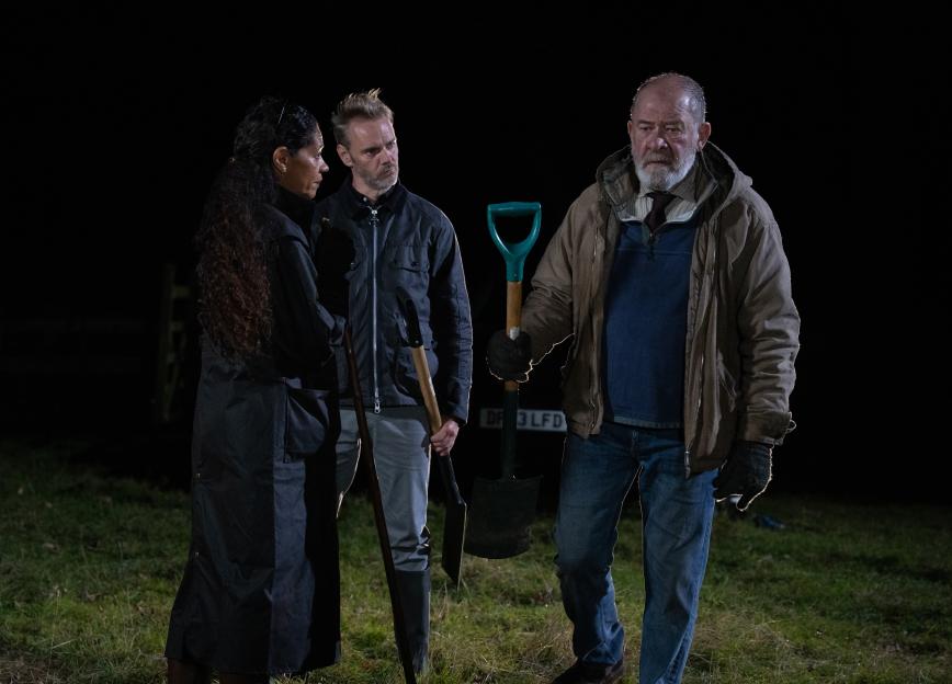 Celia, Bear, and Ray in a field at night during Anya's makeshift funeral.