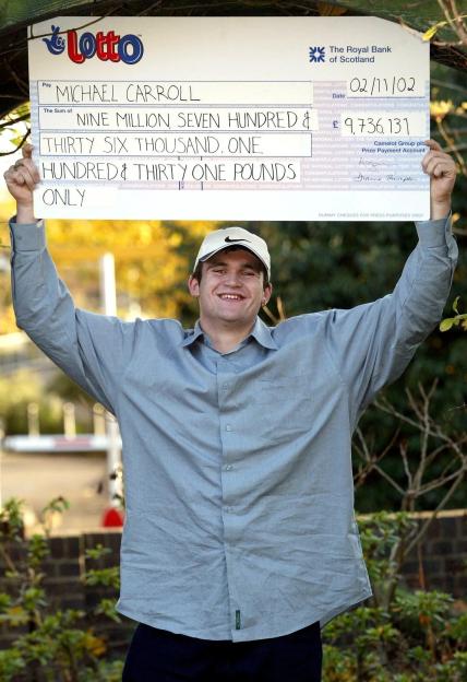 Michael Carroll holds a giant check for 9.5 million pounds from the National Lottery.