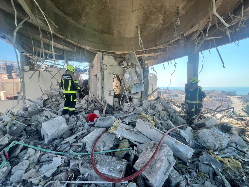 Bahrain civil defence and rescue personnel work in a residential building, which according to the Bahraini Interior Ministry, was hit by an Iranian drone, in Muharraq