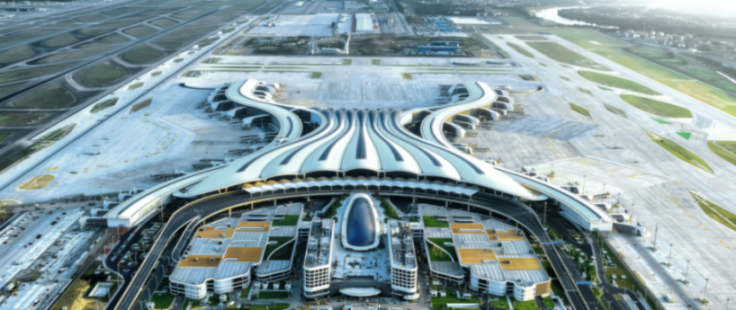 Aerial view of a sprawling modern airport with multiple runways and a uniquely designed terminal building.