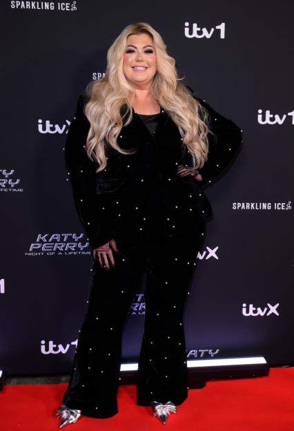 Gemma Collins posing in a black velvet suit with pearl embellishments on a red carpet at the "Katy Perry: Night Of A Lifetime" photocall.